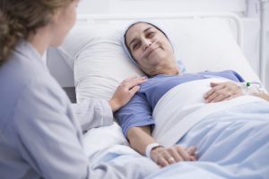 Smiling senior woman with a tumor and caring nurse in the health center