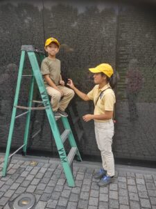 A mother and her child make rubbings of names on the Vietnam Memorial Wall